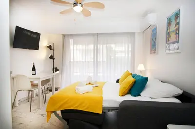 a bedroom with a bed with a yellow blanket at Le Studio Cannois Standing Presta in Cannes