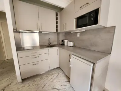 a kitchen with white cabinets and a sink at Le Studio Cannois Standing Presta in Cannes
