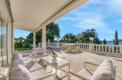 a patio with white chairs and a table at Villa d'architecte Super Cannes - Vue panoramique in Cannes