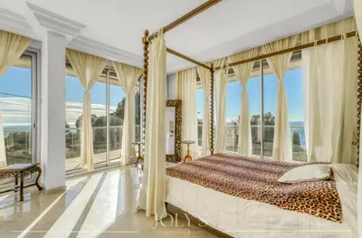 a bedroom with a canopy bed and large windows at Villa d'architecte Super Cannes - Vue panoramique in Cannes