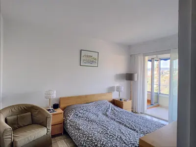 a bedroom with a bed and a chair and a window at Belle terrasse vue mer , proche plages 223L FOV in Cannes