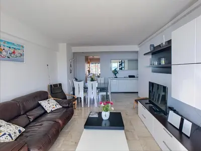 a living room with a couch and a table at Belle terrasse vue mer , proche plages 223L FOV in Cannes