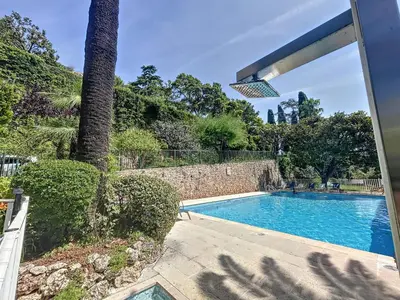 a swimming pool in a yard with a palm tree at Superbe 3 pièces vue mer 323L MUNAR in Cannes