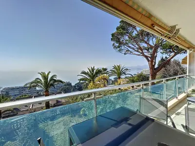 a balcony with a view of the ocean and palm trees at Superbe 3 pièces vue mer 323L MUNAR in Cannes