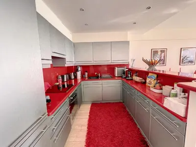 a red kitchen with white cabinets and a red rug at Superbe 3 pièces vue mer 323L MUNAR in Cannes