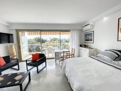 a bedroom with a bed and a table and chairs at STUDIO MIDI MAGRET Cannes in Cannes
