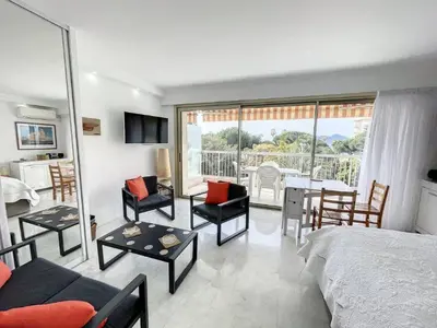 a bedroom with a bed and a table and chairs at STUDIO MIDI MAGRET Cannes in Cannes