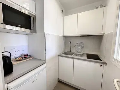 a small white kitchen with a sink and a microwave at STUDIO MIDI MAGRET Cannes in Cannes