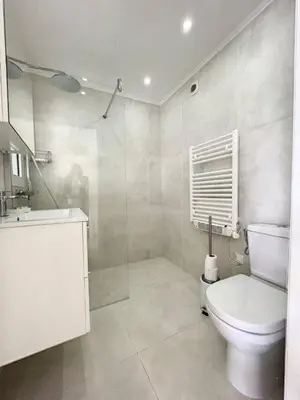a white bathroom with a toilet and a sink at STUDIO MIDI MAGRET Cannes in Cannes