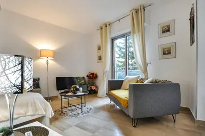 a living room with a couch and a window at Nice studio for two close to the beaches of Cannes in Cannes