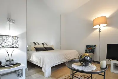 a bedroom with a bed and a table and a tv at Nice studio for two close to the beaches of Cannes in Cannes