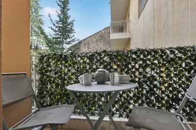 a table and chairs on a patio next to a fence at Nice studio for two close to the beaches of Cannes in Cannes