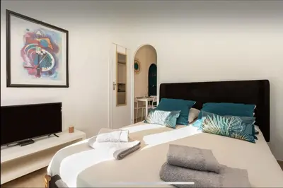 a bedroom with a large bed with a flat screen tv at Le Suquet - Château - Palais - Seaview - WIFI in Cannes