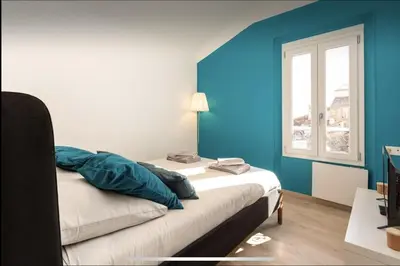 a room with a bed with blue walls and a window at Le Suquet - Château - Palais - Seaview - WIFI in Cannes