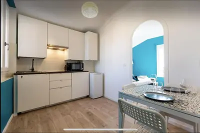 a kitchen with white cabinets and a table with chairs at Le Suquet - Château - Palais - Seaview - WIFI in Cannes