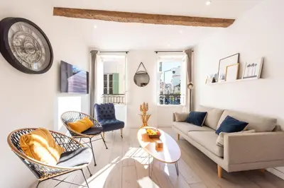 a living room with a couch and chairs and a clock at 3P Central Cannes Suquet in Cannes