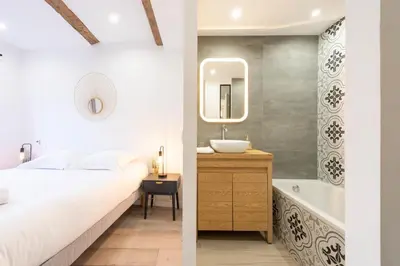 a bedroom with a bed and a sink and a tub at 3P Central Cannes Suquet in Cannes