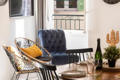 a dining room with a table with a blue chair at 3P Central Cannes Suquet in Cannes
