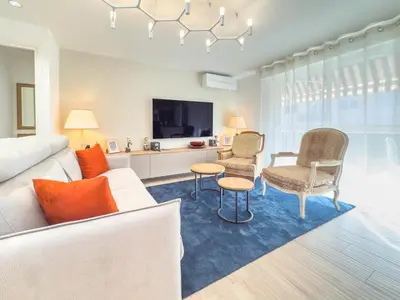 a living room with a couch and chairs and a tv at Le Marcellin by Winsome Destination in Cannes