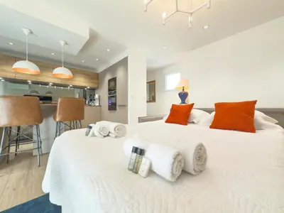 two beds in a bedroom with orange and white pillows at Le Marcellin by Winsome Destination in Cannes