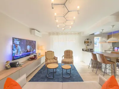 a living room with a couch and chairs and a tv at Le Marcellin by Winsome Destination in Cannes