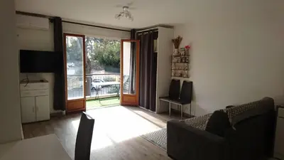 a living room with a couch and a sliding glass door at Cannes proche croisette in Cannes