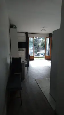 a living room with a table and chairs and a door at Cannes proche croisette in Cannes