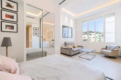 a white bedroom with a bed and a couch at REF 1975 - Cannes Center - Croisette in Cannes