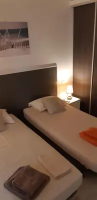 a bedroom with two beds with a large white bedvisor at Day's Inn Cannes in Cannes