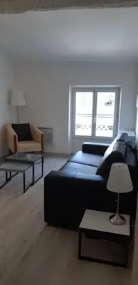 a living room with a black couch and two tables at Day's Inn Cannes in Cannes