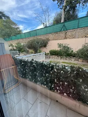a stone retaining wall with a green hedge at Le Chevreuse Cannes centre-ville in Cannes