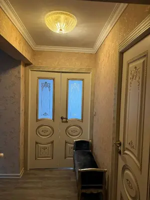 a hallway with a door with a couch and a chandelier at Le Chevreuse Cannes centre-ville in Cannes