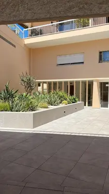a building with a courtyard with plants in front of it at Le Chevreuse Cannes centre-ville in Cannes