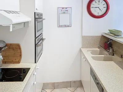 a kitchen with a sink and a clock on the wall at Bel appartement à 2 pas des plages 151L DEBL in Cannes