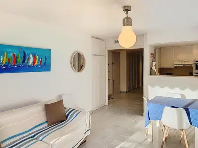 a bedroom with a bed and a table and a kitchen at Bel appartement à 2 pas des plages 151L DEBL in Cannes