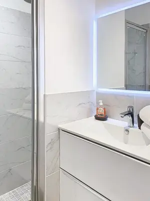 a white bathroom with a sink and a shower at 3p Quai St Pierre - 348L Alexa in Cannes