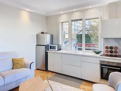 a white kitchen with a refrigerator and a couch at 3p Quai St Pierre - 348L Alexa in Cannes