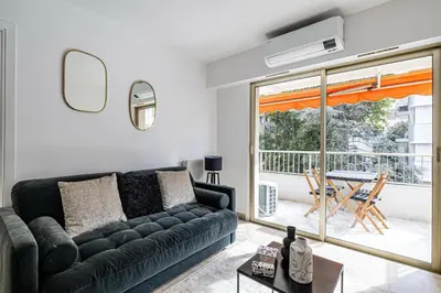 a living room with a black couch and a table at Joli 2 pcs - Prox Martinez in Cannes
