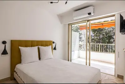 a bedroom with a bed and a sliding glass door at Joli 2 pcs - Prox Martinez in Cannes