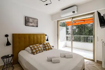 a bedroom with a large bed and a balcony at Joli 2 pcs - Prox Martinez in Cannes