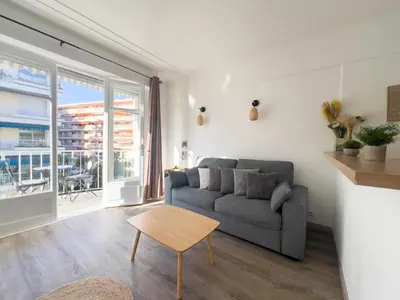 a living room with a couch and a table at Calme et centrale avec balcon ensoleillé in Le Cannet