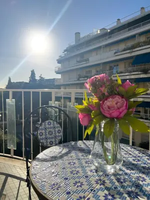 a vase of flowers sitting on a table on a balcony at Calme et centrale avec balcon ensoleillé in Le Cannet