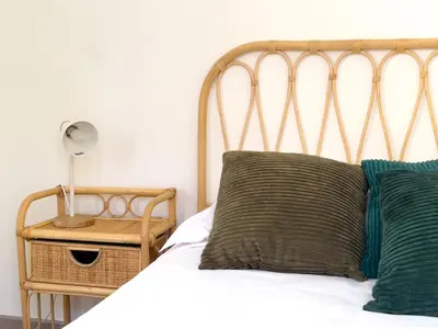 a bed with two pillows and a lamp on a table at Calme et centrale avec balcon ensoleillé in Le Cannet