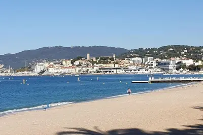a person walking on a beach near the water at Cannes Croisette Loft vue mer in Cannes