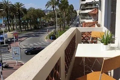 a balcony with a table and chairs and a street at Cannes Croisette Loft vue mer in Cannes