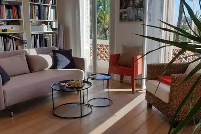 a living room with a couch and two tables at Cannes Croisette Loft vue mer in Cannes
