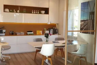 a dining room with a table and chairs and a kitchen at Cannes Croisette Loft vue mer in Cannes