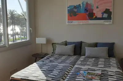 a bed in a bedroom with a picture on the wall at Cannes Croisette Loft vue mer in Cannes