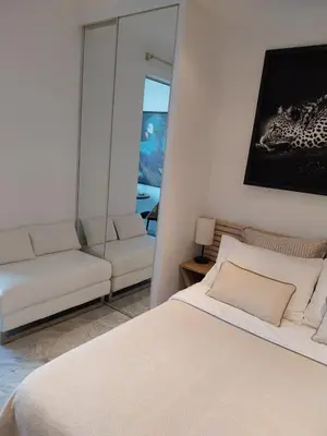a bedroom with a white bed and a mirror at Palm beach Cannes La Brise in Cannes