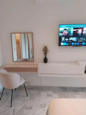 a living room with a mirror and a tv on the wall at Palm beach Cannes La Brise in Cannes